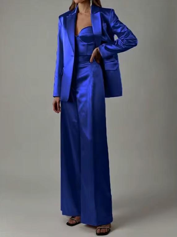 Royal blue satin two-piece suit with a sharp blazer, corset-style top, and high-waisted wide-leg trousers.