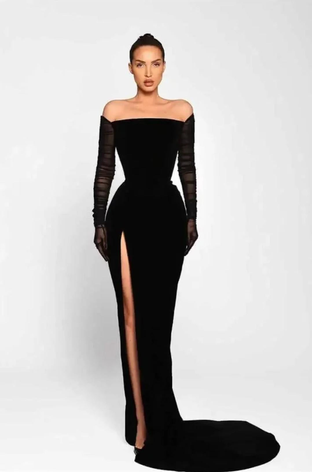 Black off-shoulder floor-length gown with sheer long sleeves, a high leg slit, and a fitted silhouette.