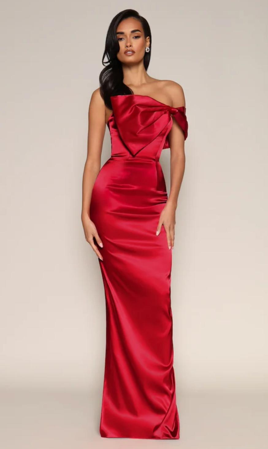 Red satin floor-length evening gown with a one-shoulder bow detail and a fitted trumpet silhouette.