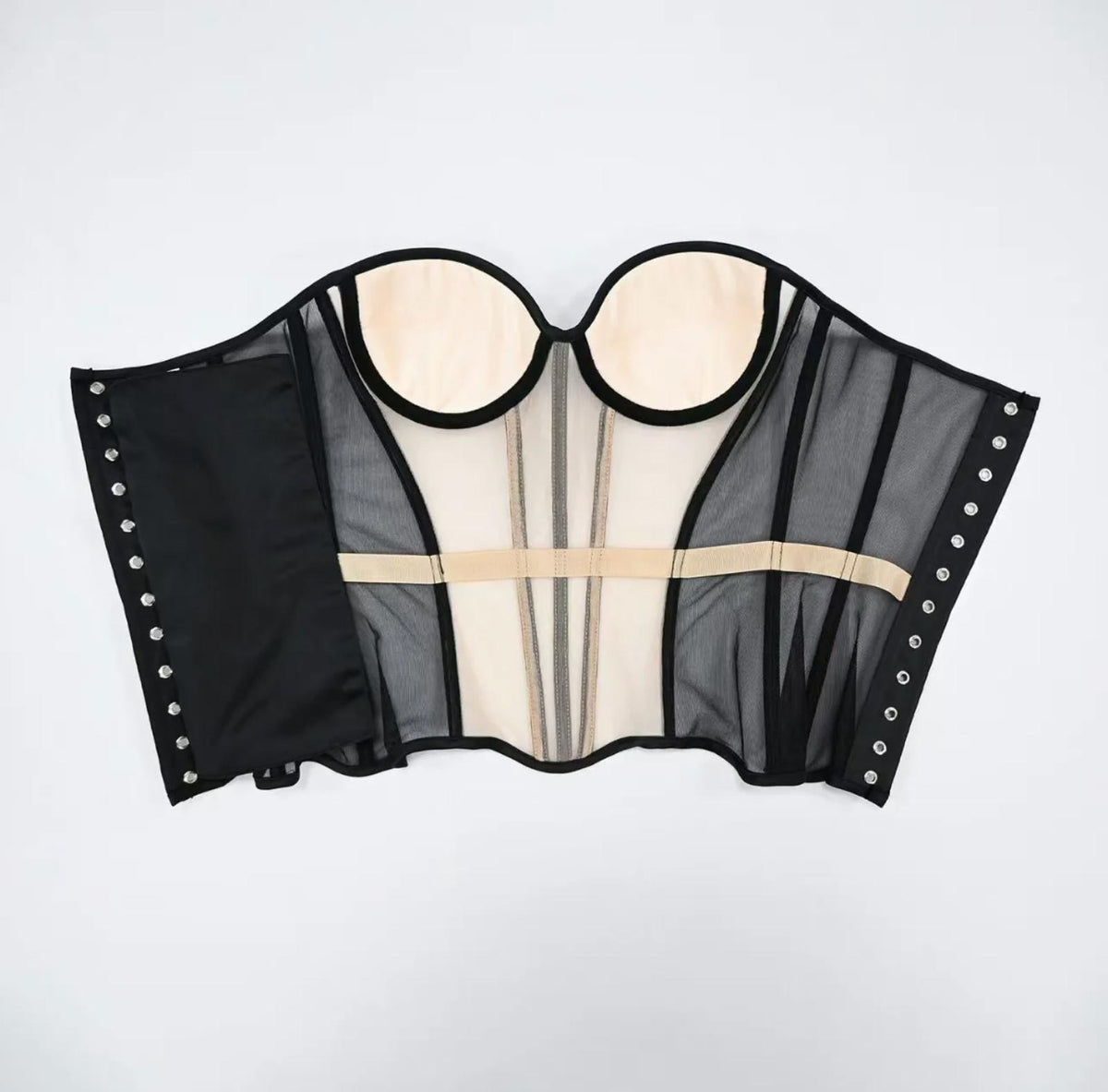 Dora strapless corset in black mesh and beige fabric with structured boning and side hook-and-eye closures.