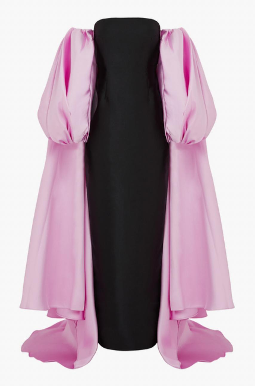 Black strapless satin evening gown featuring dramatic, removable pink puff sleeve cape and full-length silhouette.