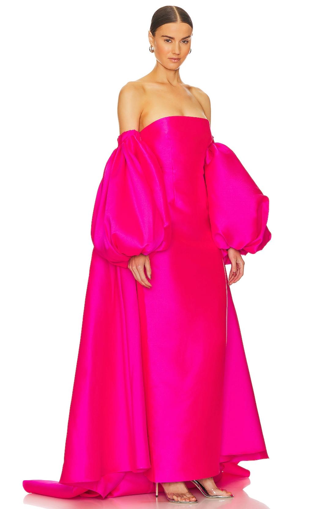 Hot pink strapless evening gown in Mikado satin with voluminous puff sleeves and a floor-length straight hem.