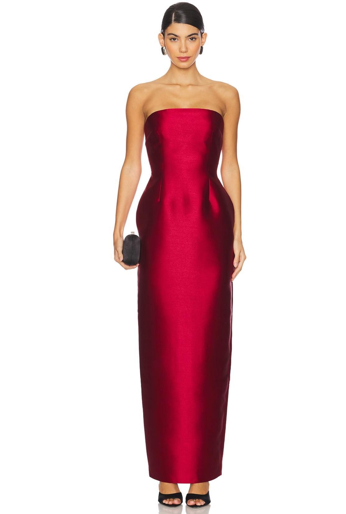 Model wearing a strapless, full-length red Mikado satin evening gown with a structured bodice and straight hem.