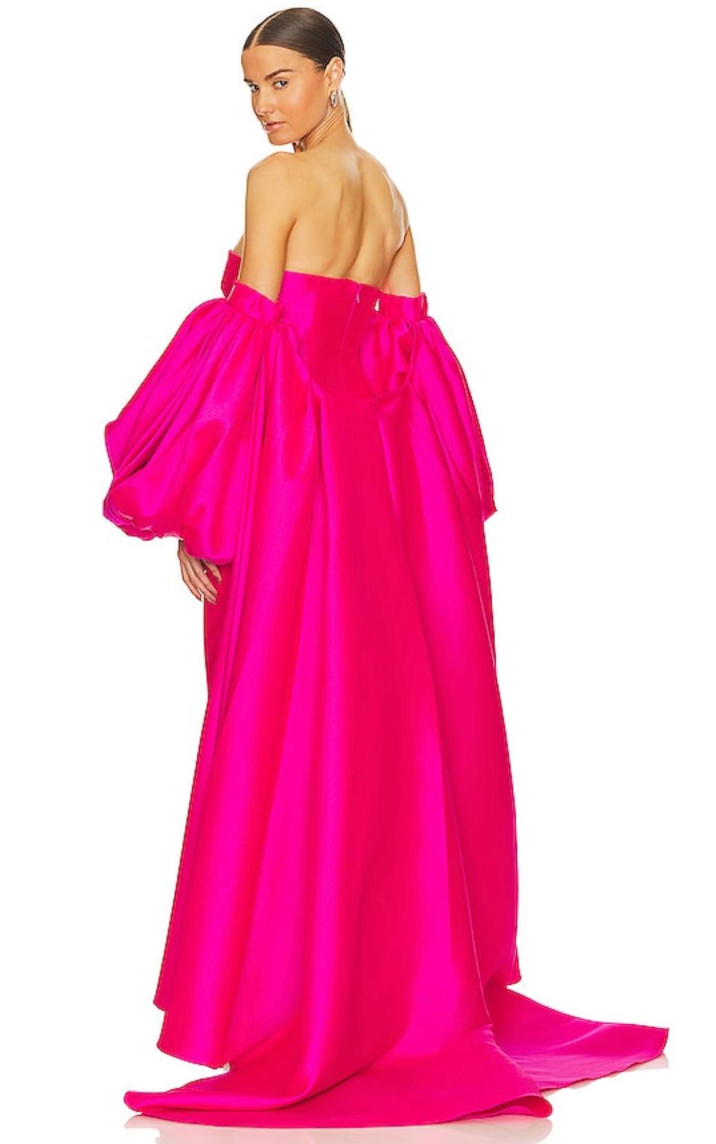 Hot pink strapless satin evening gown with a removable puff sleeve cape and a dramatic floor-length train.