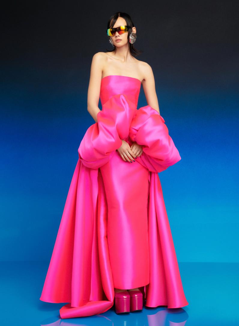 Hot pink strapless Mikado satin evening gown with a removable puff sleeve cape and full-length straight hem.