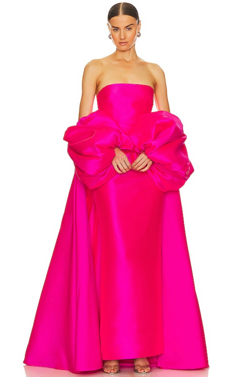 Hot pink strapless satin evening gown featuring a structured bodice and dramatic removable puff sleeve cape.
