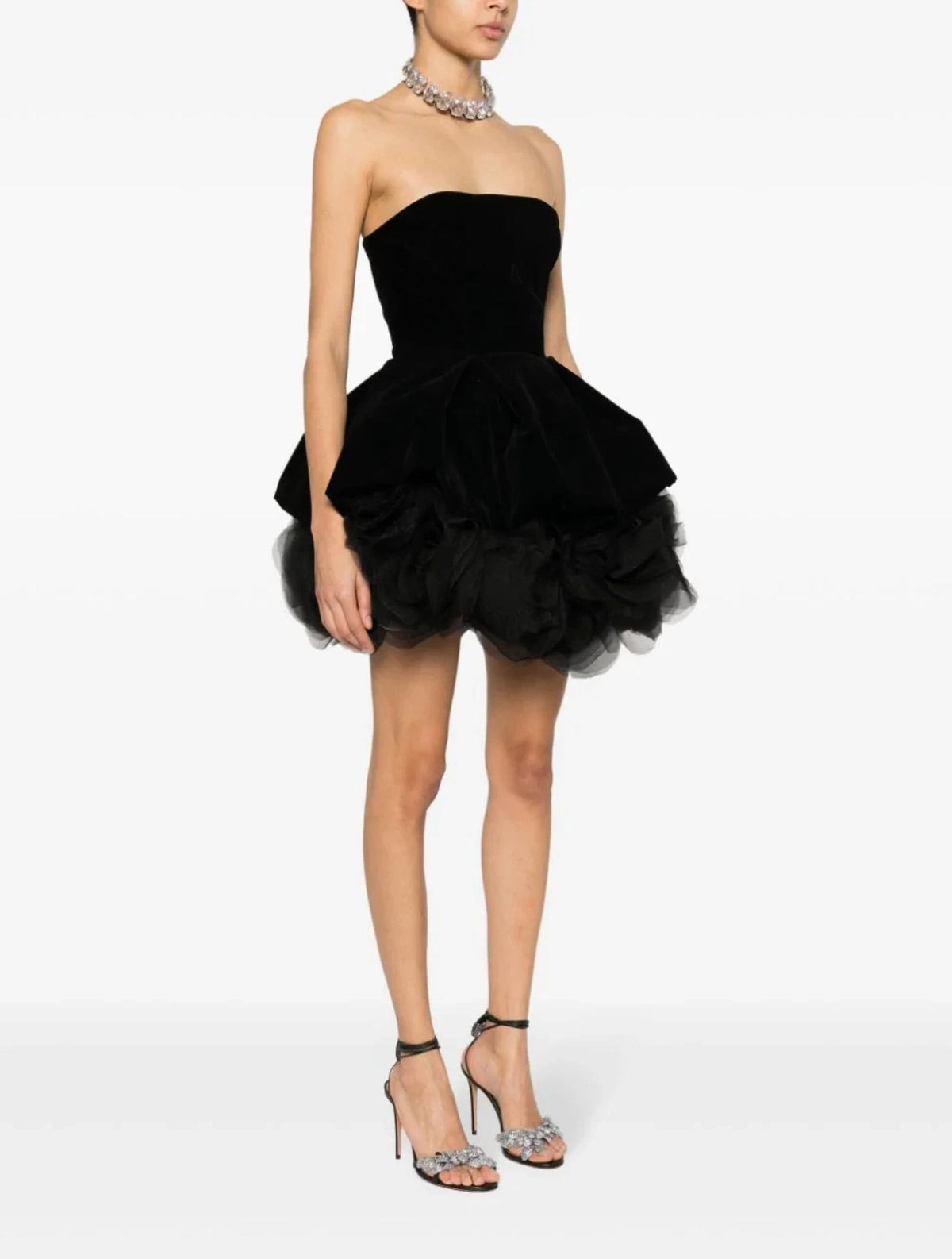 Black strapless mini dress with a sweetheart neckline, voluminous tulle skirt, and handmade floral accents.