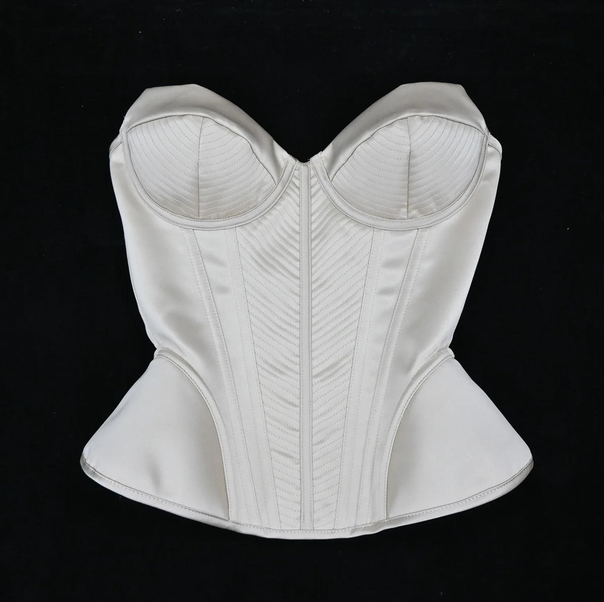 Enni luxury ivory satin corset bustier with structured boning and intricate stitched panel detailing.