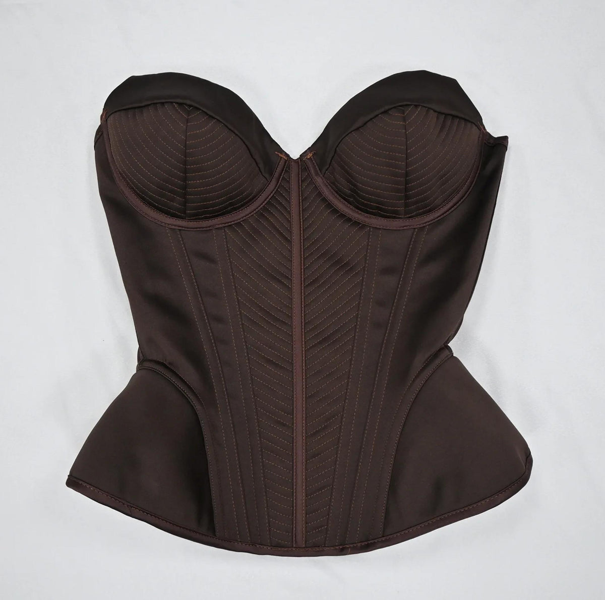 Dark brown structured corset bustier with intricate stitched detailing and a vintage-inspired sculpted silhouette.