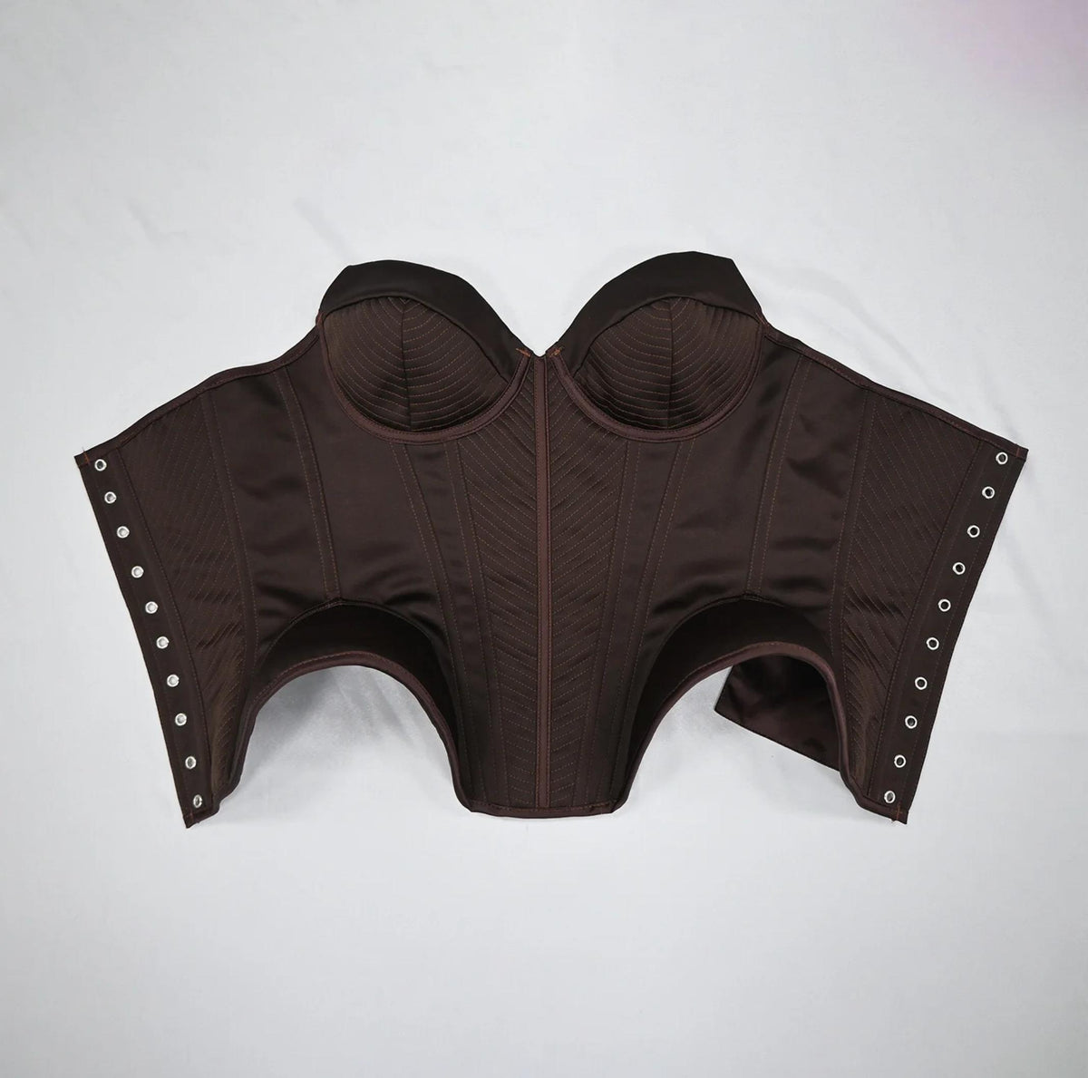 Dark brown structured corset bustier with stitched detailing, sweetheart neckline, and side metal eyelets for lacing.