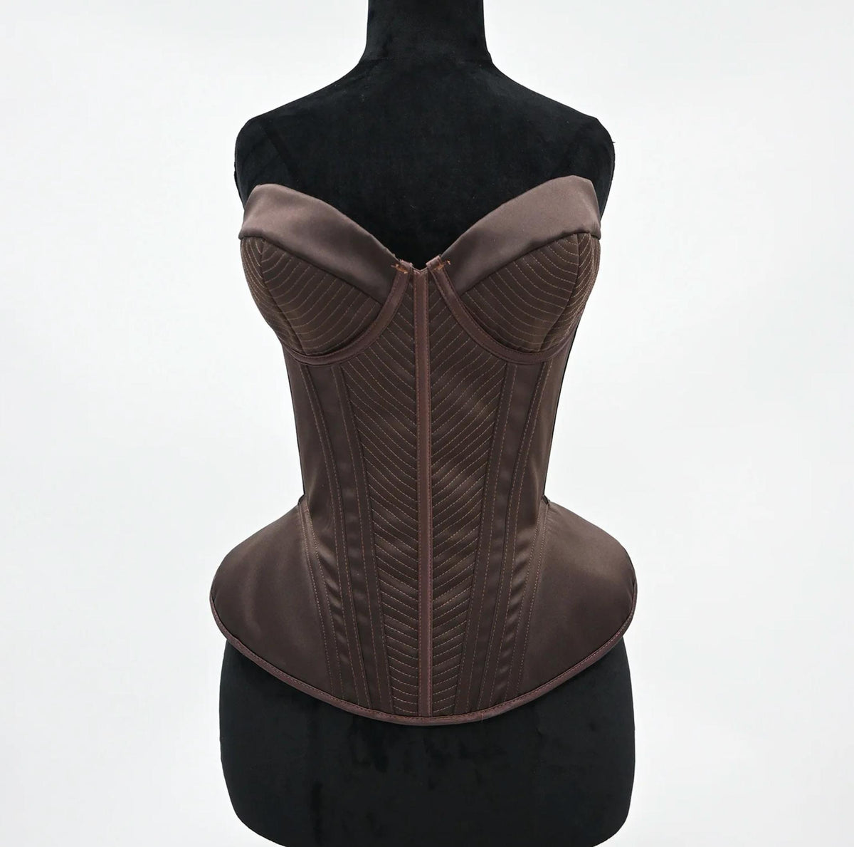 Structured dark brown satin corset bustier with intricate chevron stitching and a sculpted, vintage-inspired silhouette.