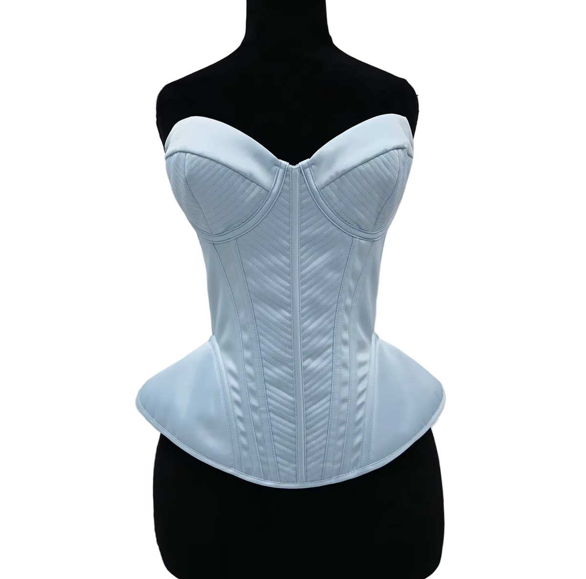 Light blue structured corset bustier with quilted stitching and a peplum waist on a black mannequin.