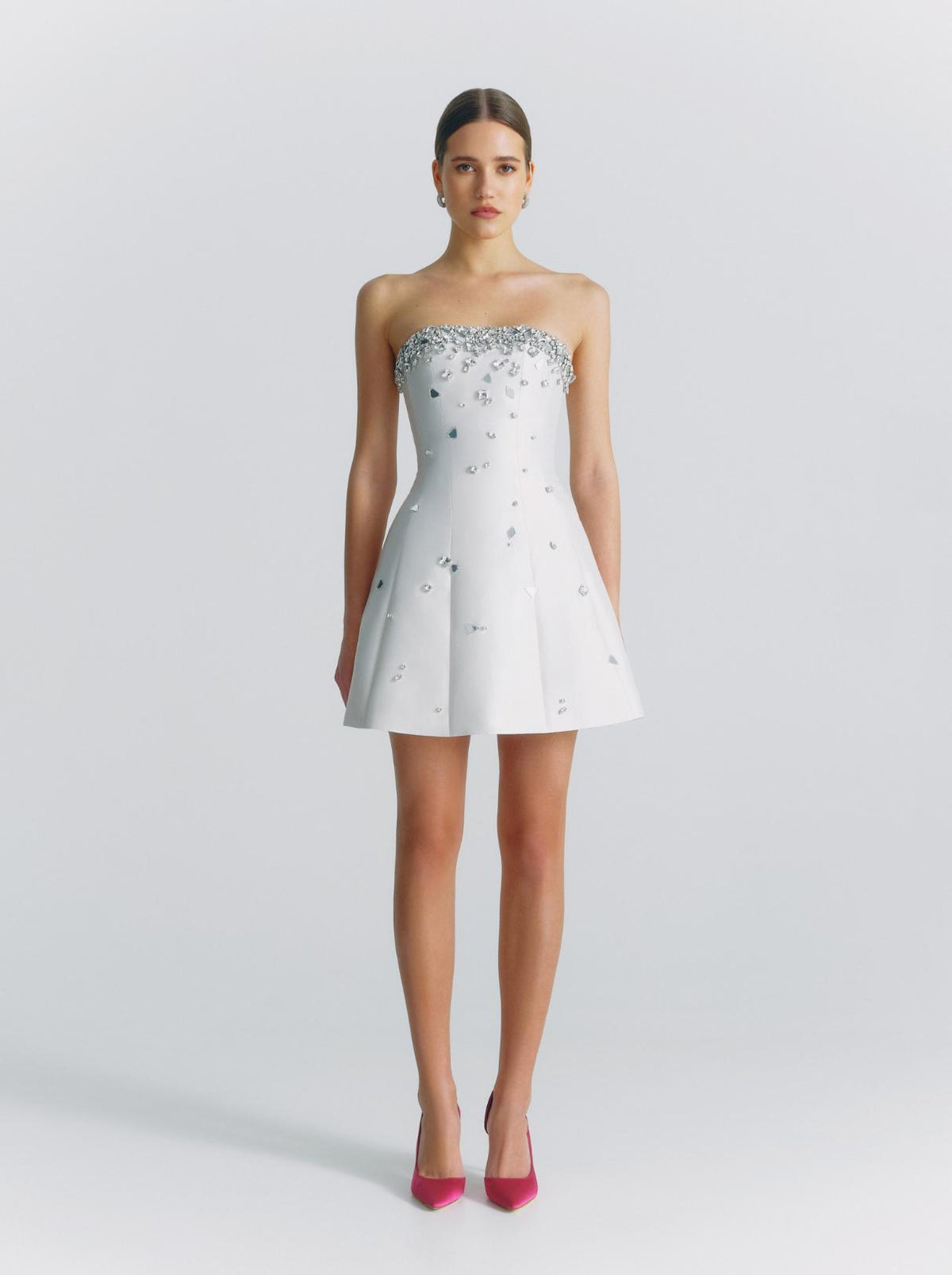 White strapless satin mini dress featuring a crystal-embellished neckline and scattered rhinestones on a flared skirt.