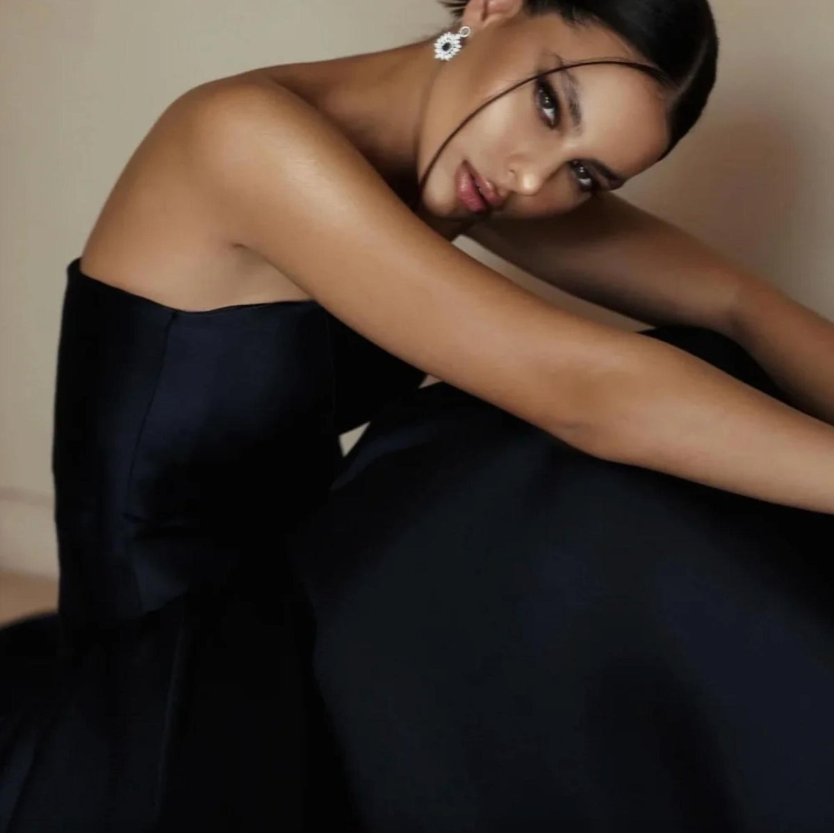 Elegant black strapless satin A-line evening gown with a fitted bodice, perfect for formal events.