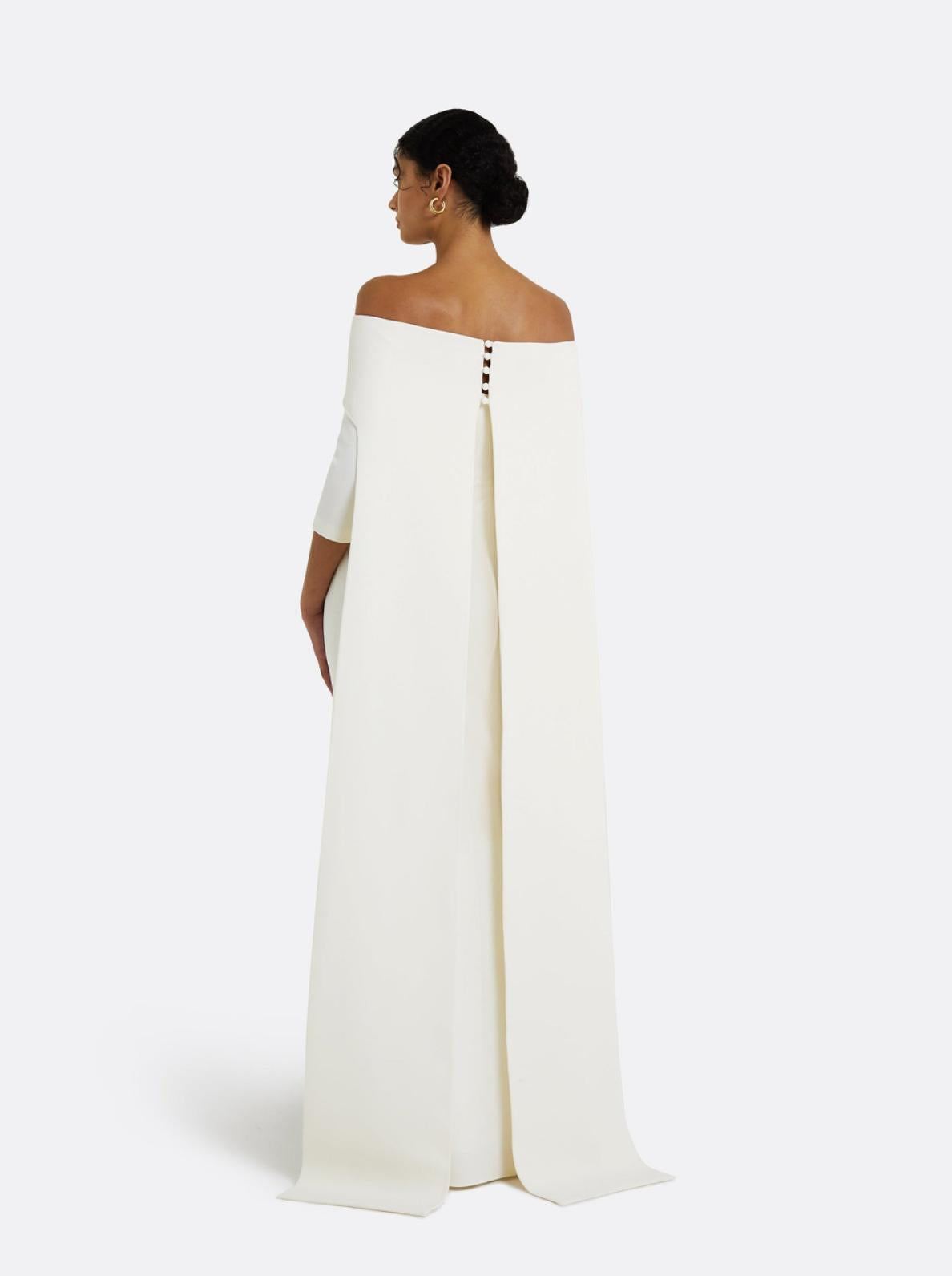 Off-the-shoulder white floor-length gown with a dramatic back train and button detailing in smooth polyester.