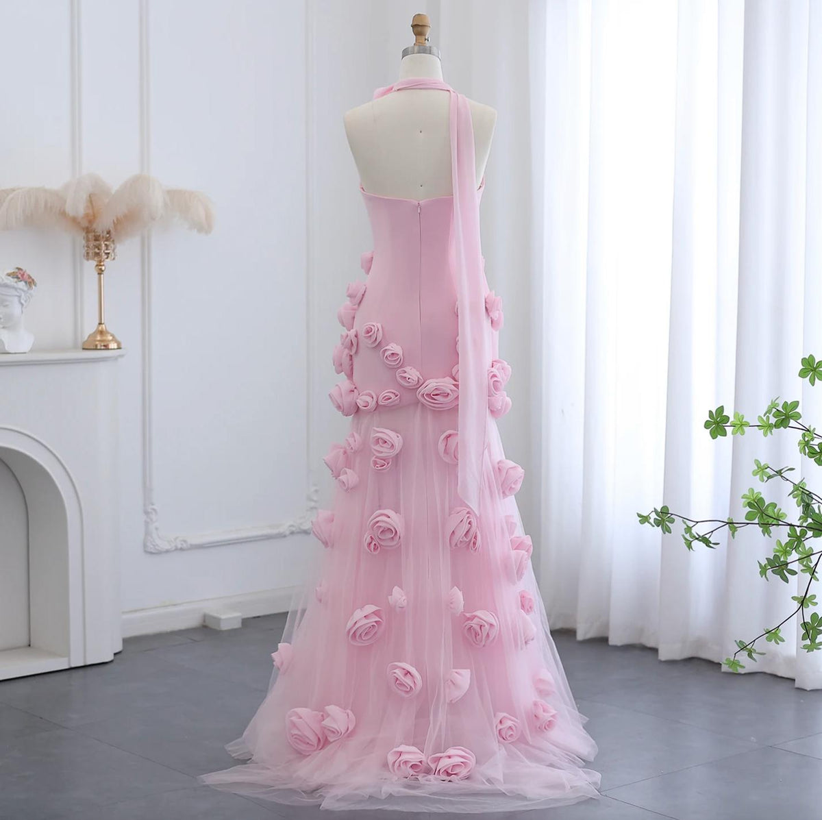 Back view of a pink trumpet gown featuring 3D floral rose appliqués, a sweetheart neckline, and a sweeping tulle train.