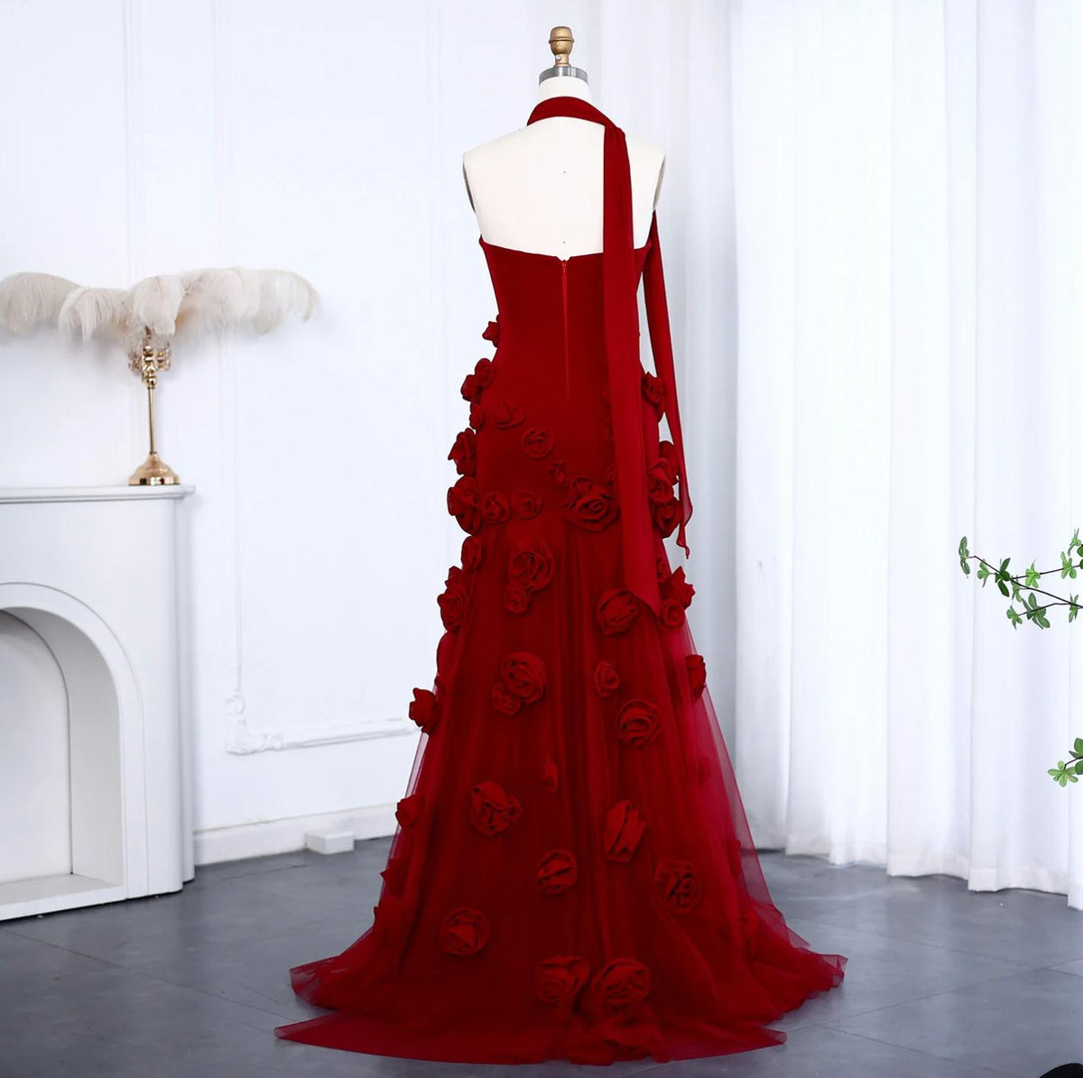 Red trumpet gown featuring 3D floral appliqués, a sweetheart neckline, and a sweeping tulle train on a mannequin.