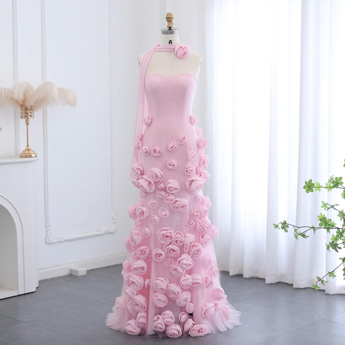 Pink tulle Evelyn Walk trumpet gown with a sweetheart neckline and intricate 3D floral appliqués on a mannequin.