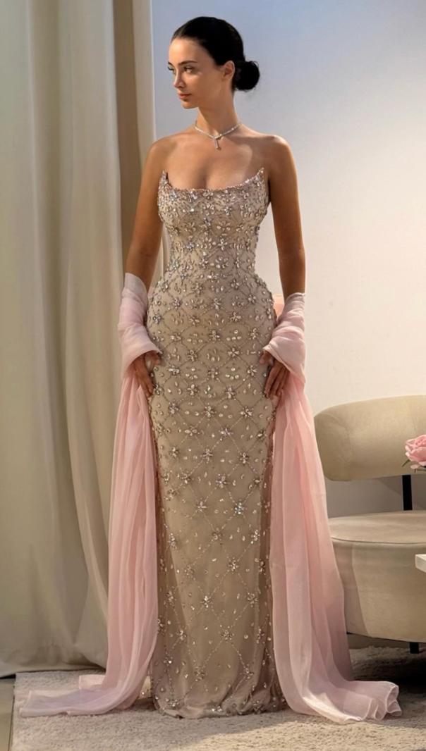Beige sleeveless evening gown with intricate crystal beading, scoop neckline, and a flowing light pink coordinating shawl.