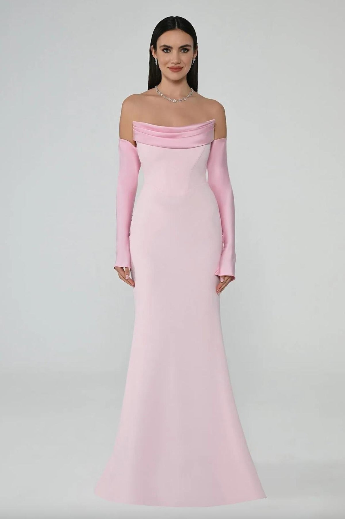 Light pink satin mermaid evening gown with a strapless pleated neckline and matching long sleeves.