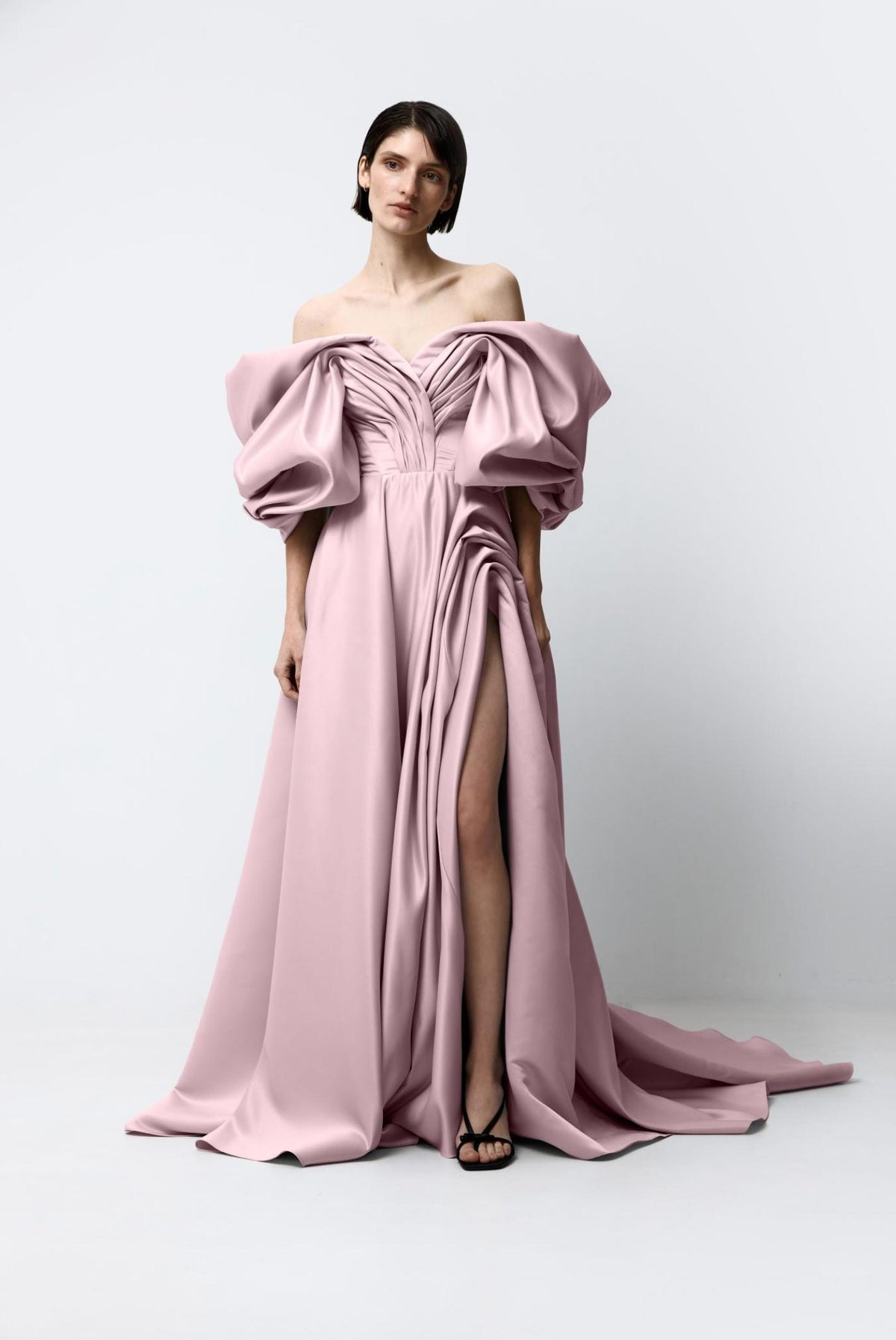 Dusty pink off-shoulder satin A-line gown with voluminous sleeves, pleated bodice, and a high side slit.