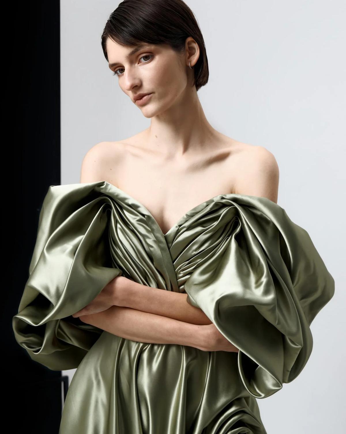 Sage green off-shoulder satin gown with voluminous pleated sleeves and a luxurious vintage-inspired silhouette.