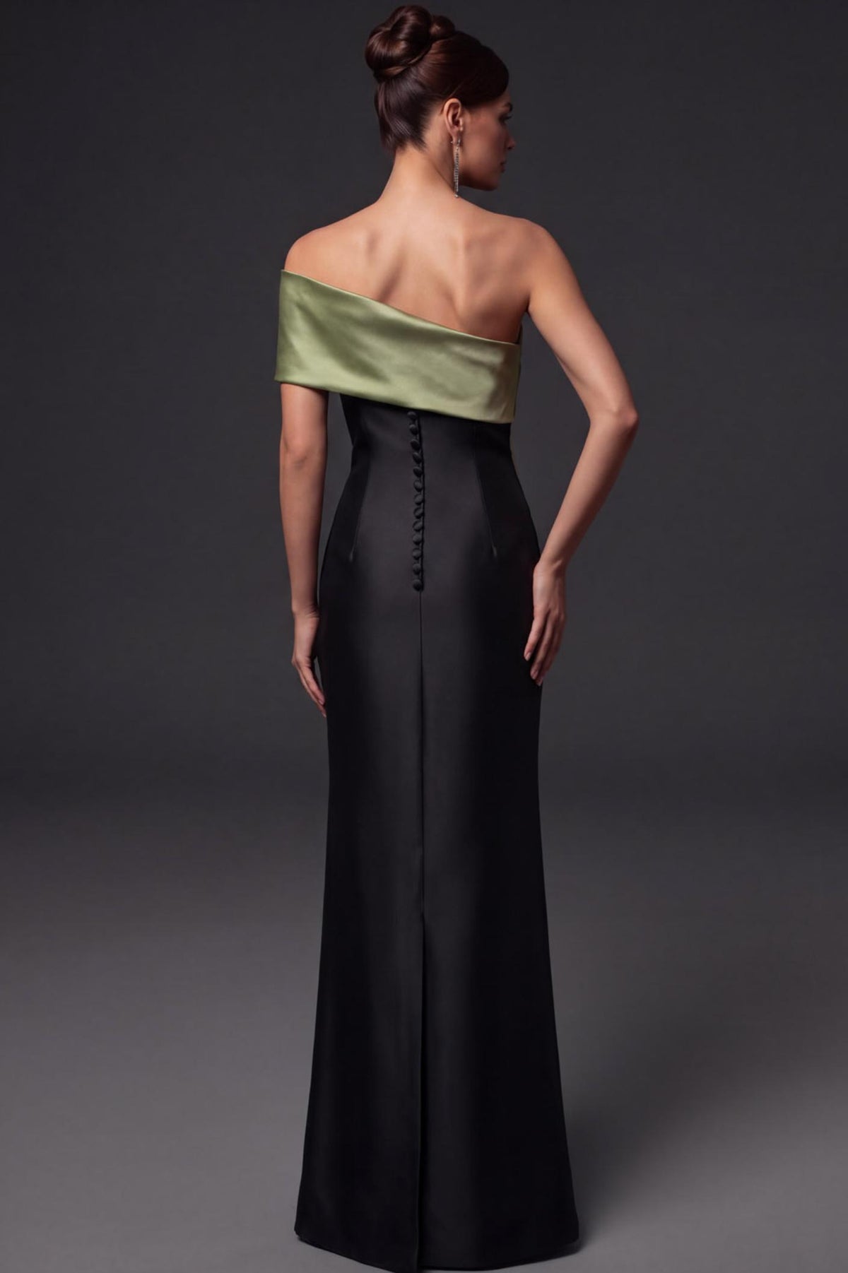 Back view of a black satin twill floor-length gown with a sage green off-shoulder bodice and elegant button-up back detail.