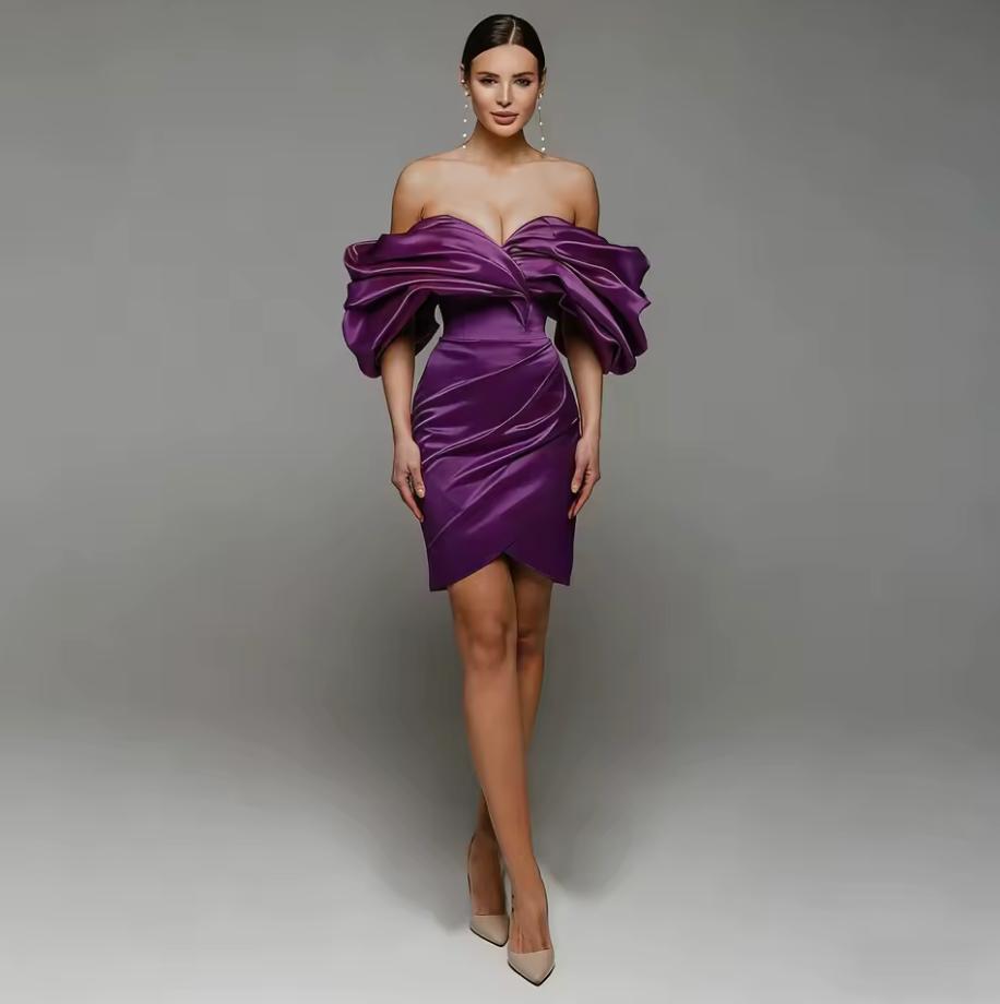 Model wearing a purple satin Faustini mini gown with an off-shoulder sweetheart neckline and pleated A-line skirt.
