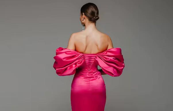 Hot pink satin mini gown with off-shoulder puff sleeves and a lace-up corset back design.
