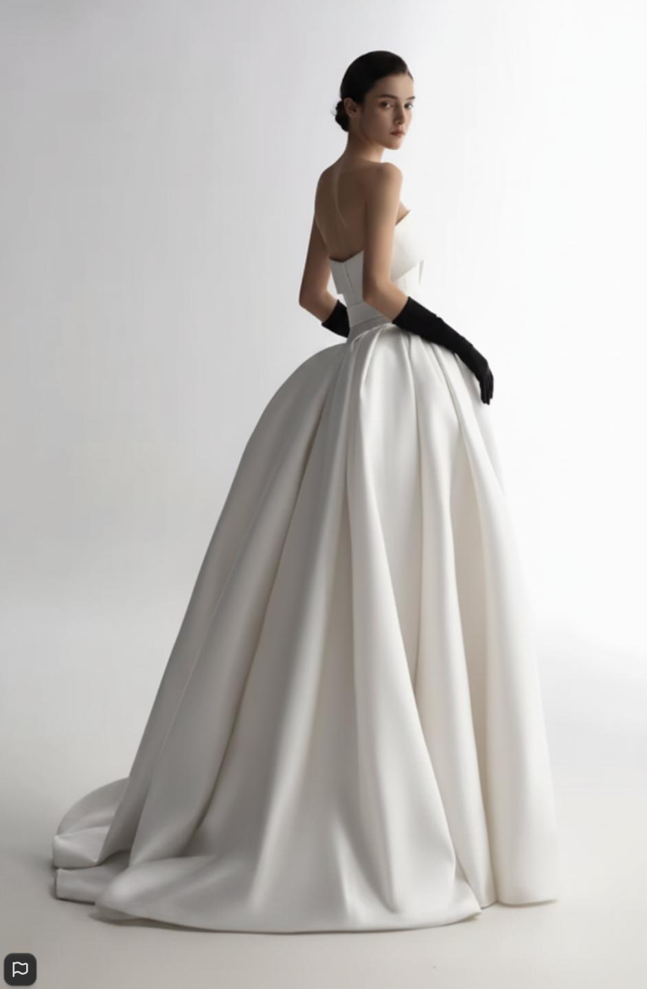 Strapless white satin A-line ball gown with a full skirt and elegant black opera gloves.