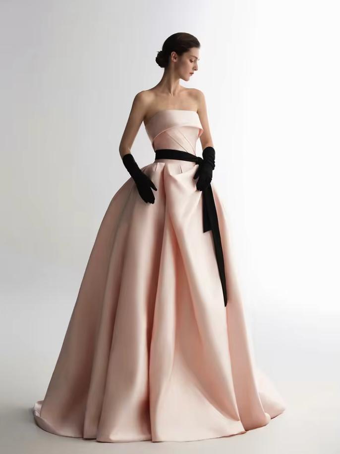 Strapless pink satin A-line ball gown with a black ribbon waist and matching opera-length gloves.