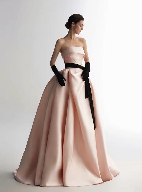 Strapless pink satin A-line ball gown with a black waist ribbon and matching opera-length gloves.