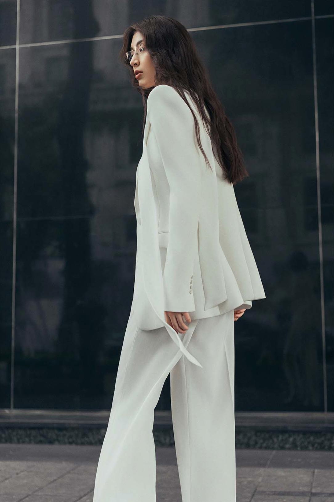 Woman wearing a sleek white Italian satin suit set with a tailored one-button jacket and matching trousers.
