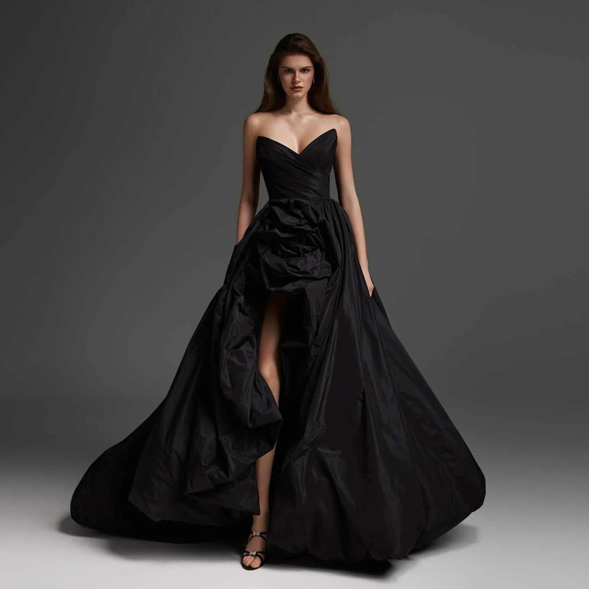 Elegant black taffeta maxi gown with a strapless sweetheart neckline, ruffled skirt, and high-low hemline.