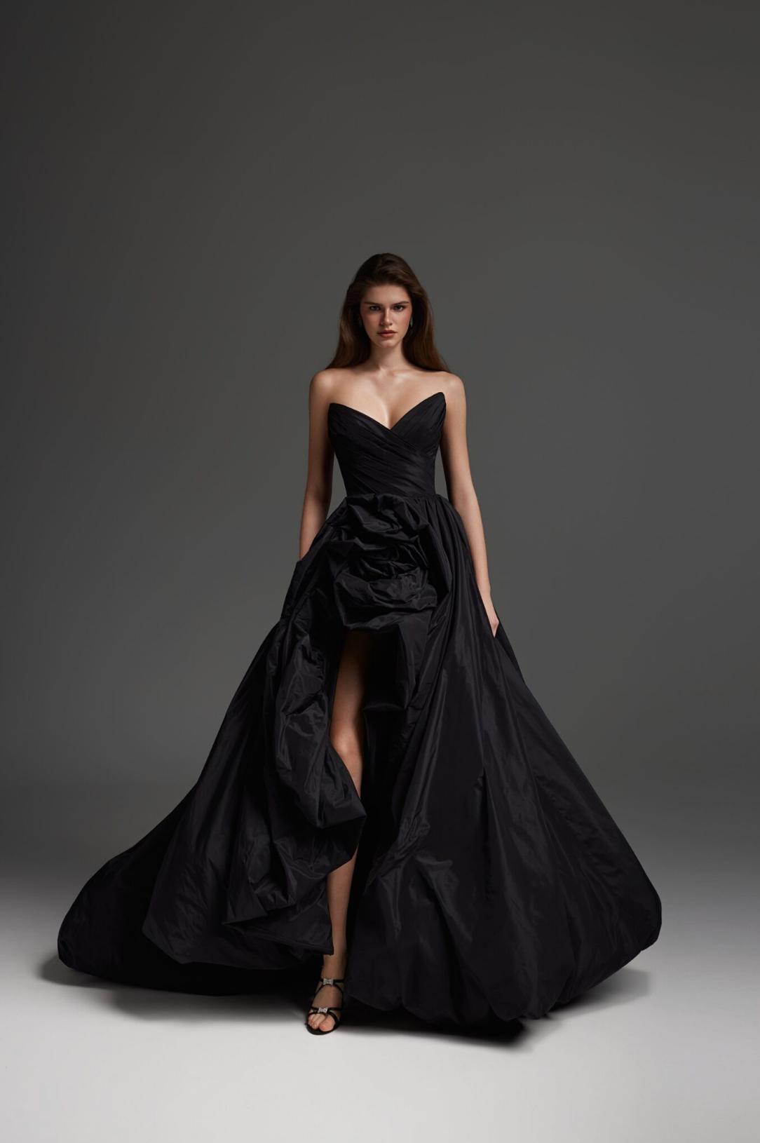 Model wearing a black taffeta maxi gown with a strapless bodice, ruffled skirt, and high-low hemline.