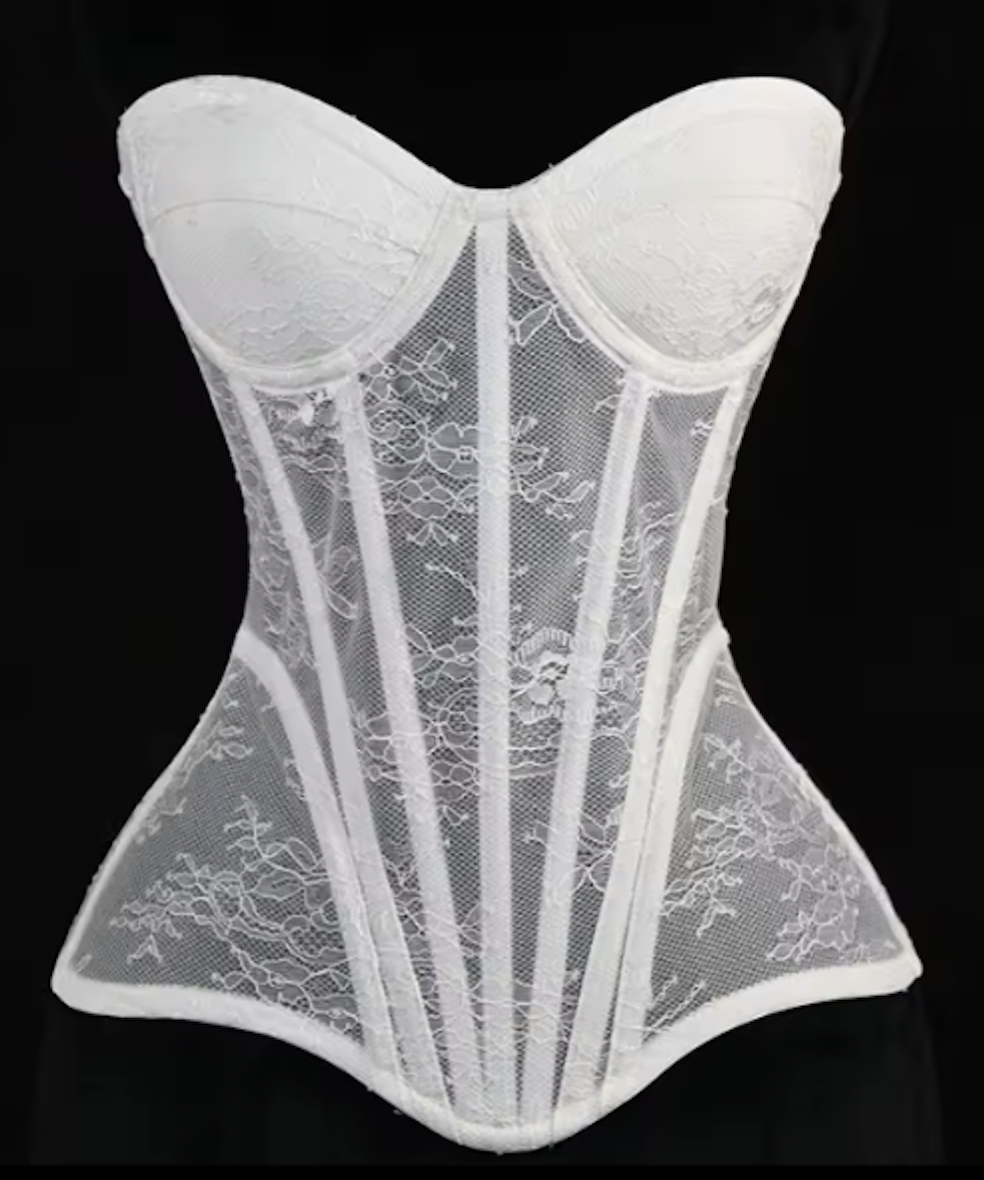 White Gia corset bustier featuring intricate lace detailing, steel-boned construction, and a sculpted waist silhouette.