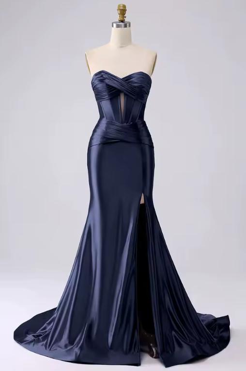 Navy blue satin mermaid gown with a sweetheart corset bodice, pleated details, and a high leg slit on a mannequin.