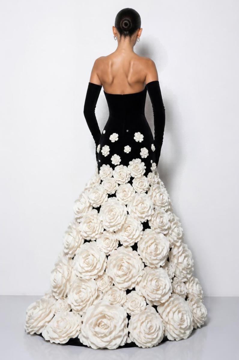 Strapless black velvet evening gown with long gloves and voluminous 3D white taffeta floral appliqués on the skirt.