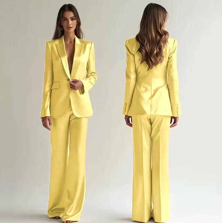 Model wearing a bright yellow satin two-piece suit with a single-button blazer and wide-leg trousers.