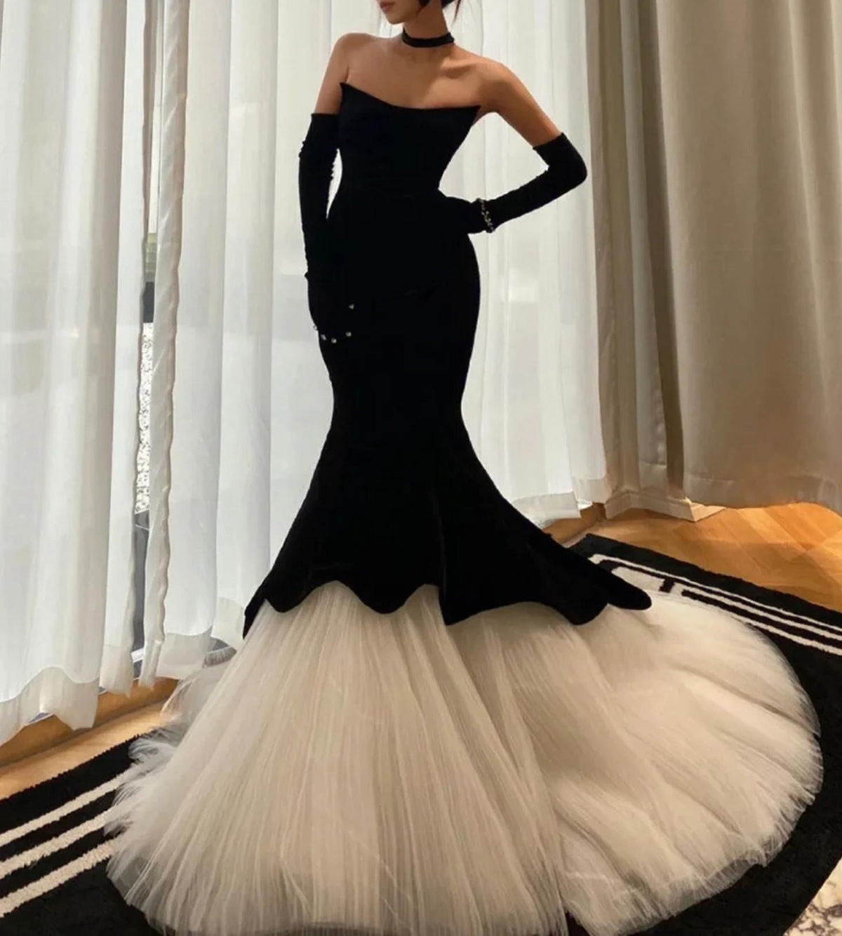 Black velvet fishtail gown with a voluminous white tulle skirt and matching opera gloves.