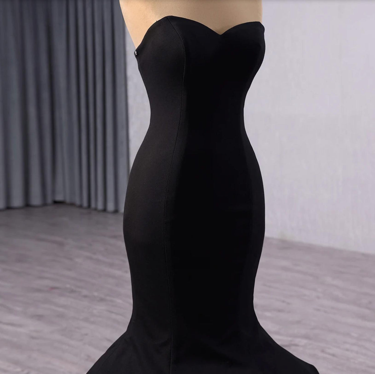 Sleeveless black velvet fishtail gown with a sweetheart neckline and form-fitting silhouette.