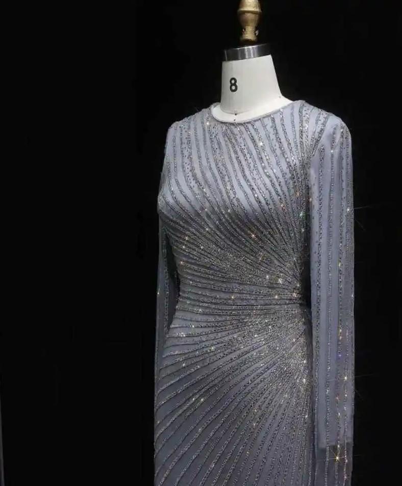 Grey floor-length evening gown with long sheer sleeves, intricate silver beading, and a flattering o-neck silhouette.