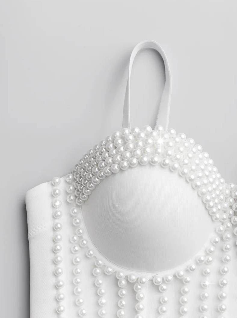 White handmade corset camisole featuring intricate pearl bead embellishments and a structured, modern design.