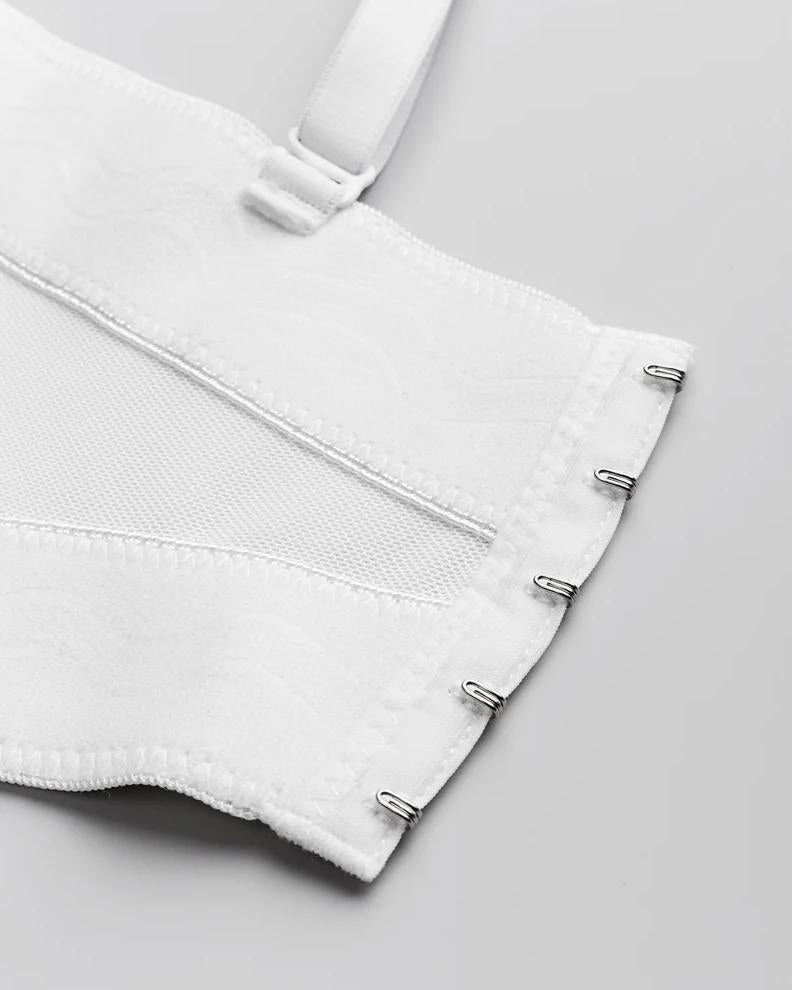 White handmade corset back with metal hook-and-eye closures, mesh panels, and adjustable strap detail.