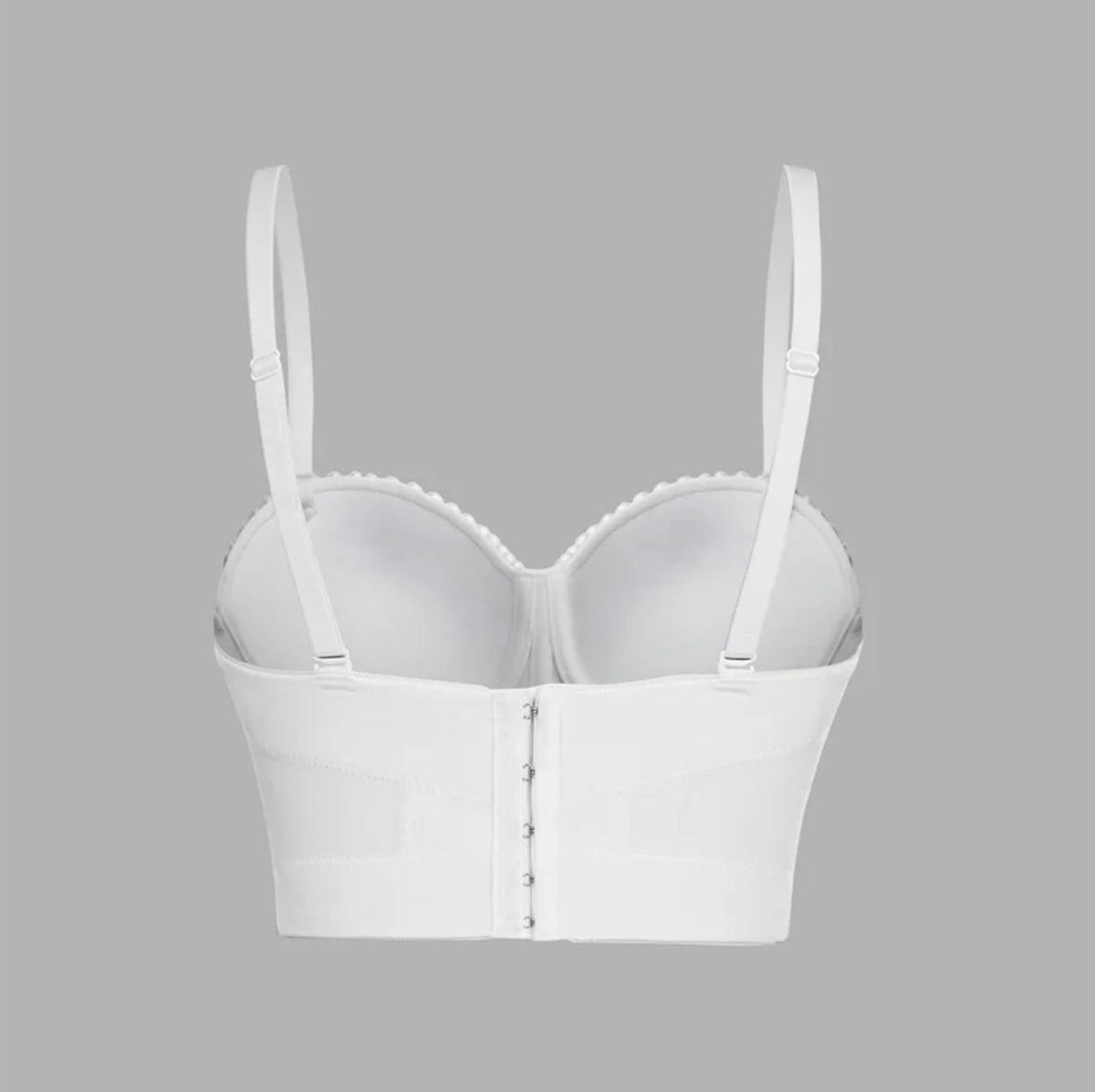 White handmade corset camisole with adjustable straps, hook-and-eye back closure, and structured, fitted silhouette.