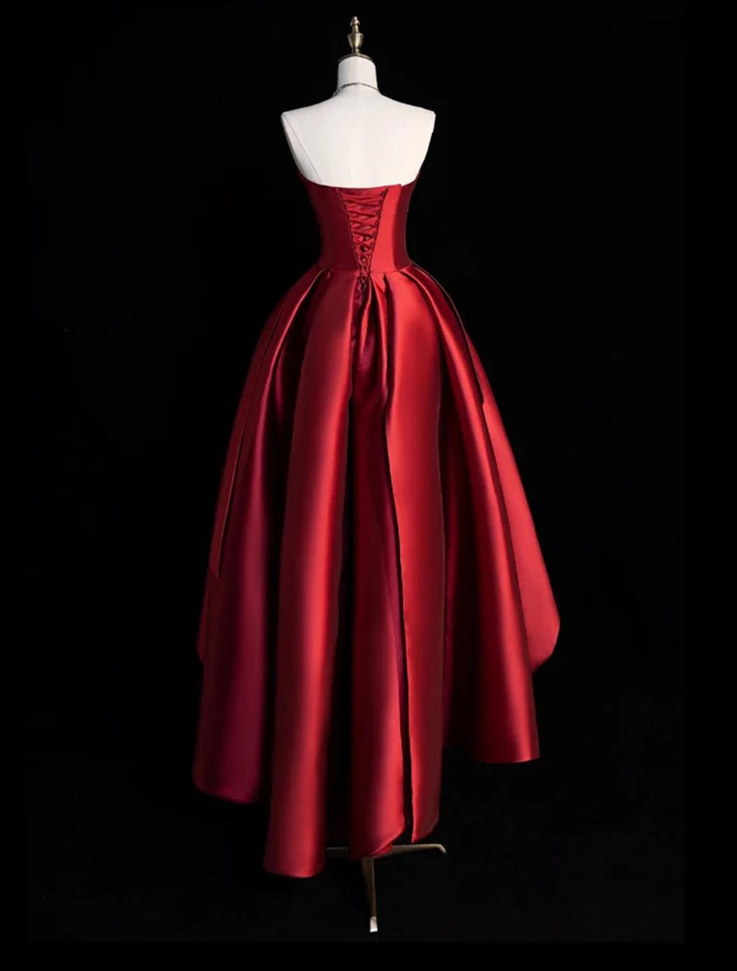 Red satin strapless midi dress with a corset back and pleated high-low A-line skirt on a mannequin.