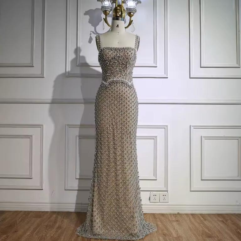 Ivar mermaid gown with a square neckline, featuring intricate silver beading and crystal embellishments on a floor-length silhouette.