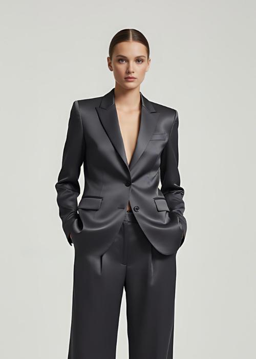 Model wearing a dark gray satin pantsuit with a tailored single-breasted blazer and matching wide-leg trousers.