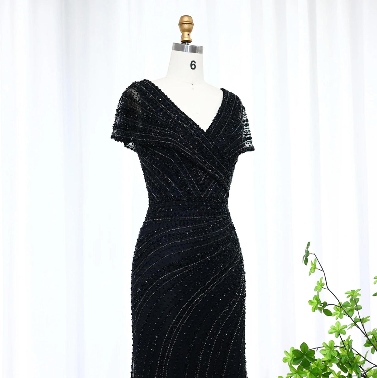Black mermaid evening gown with V-neck, short sleeves, and intricate beaded swirl patterns on a size 6 mannequin.