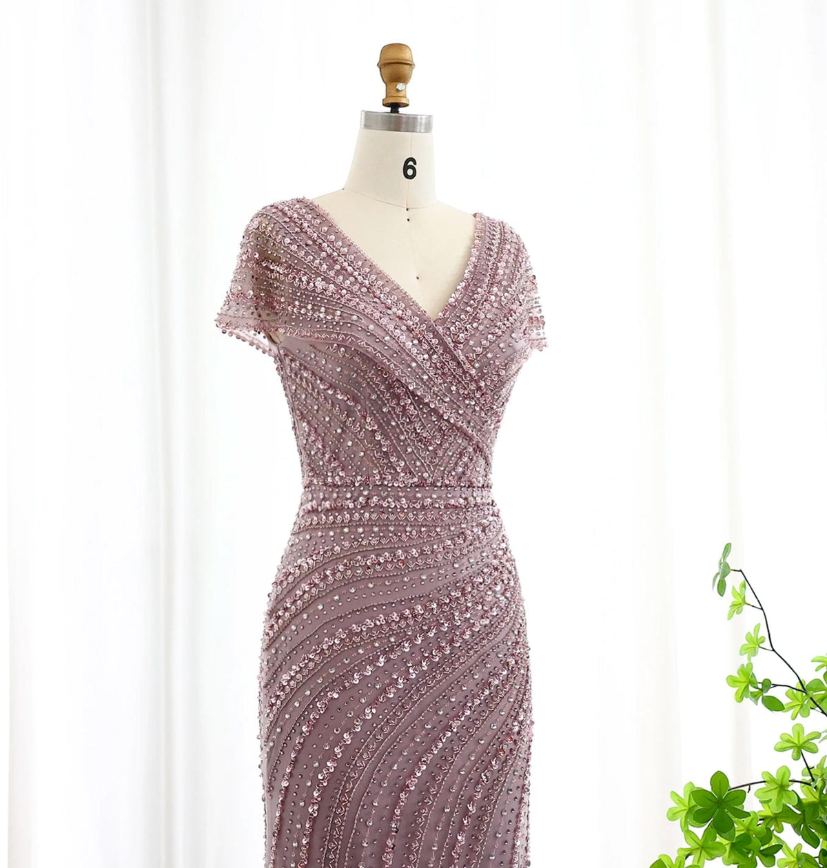 Silver nude mermaid gown with V-neck, intricate crystal and sequin beading on a mannequin.